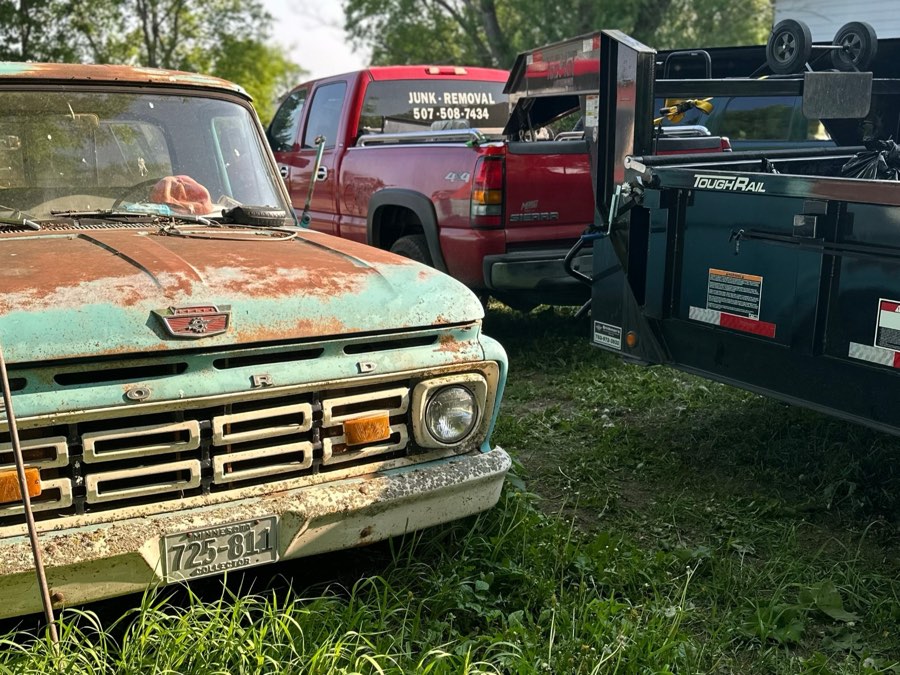 The South Central Hauling and Junk Removal truck and trailer hauling away an old pickup